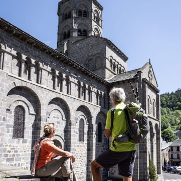 Hiking couple in front of the Orcival basilica