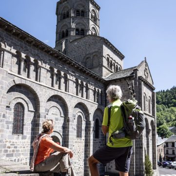 Couple randonneur devant la basilique d'Orcival