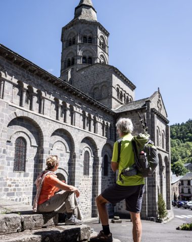 Hiking couple in front of the Orcival basilica